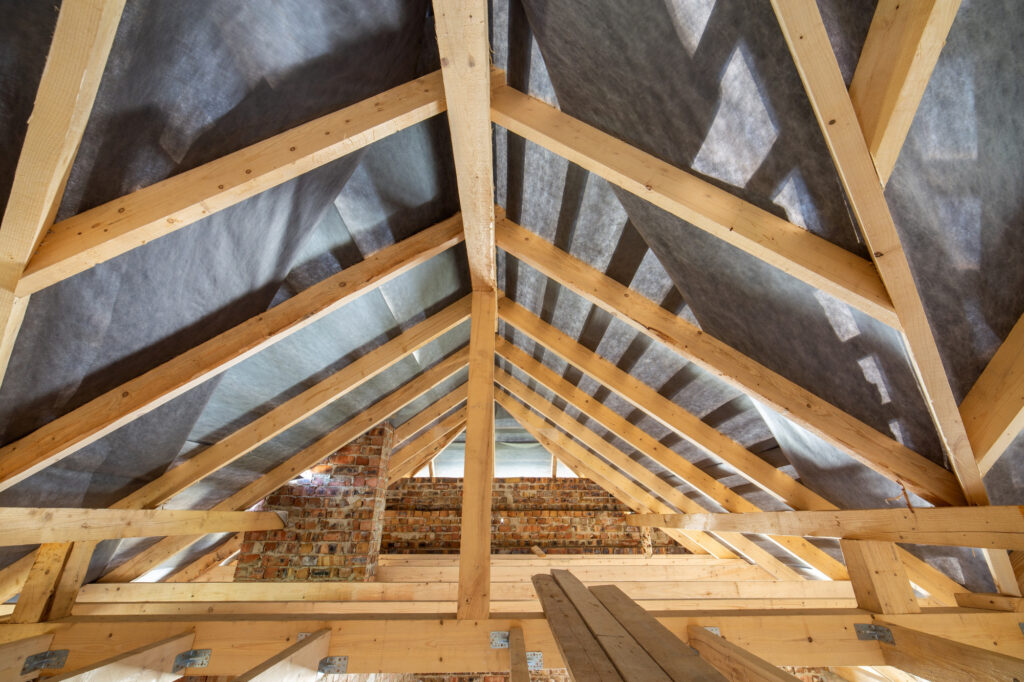 Charpente en bois avec isolation sous toiture dans un grenier