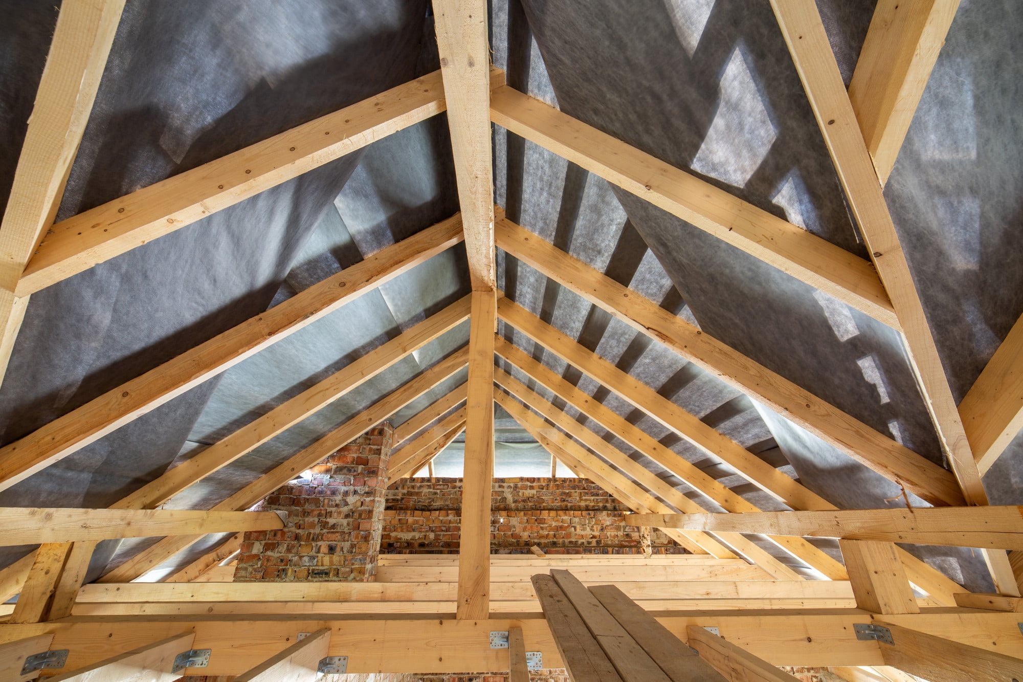 Charpente en bois avec isolation sous toiture dans un grenier